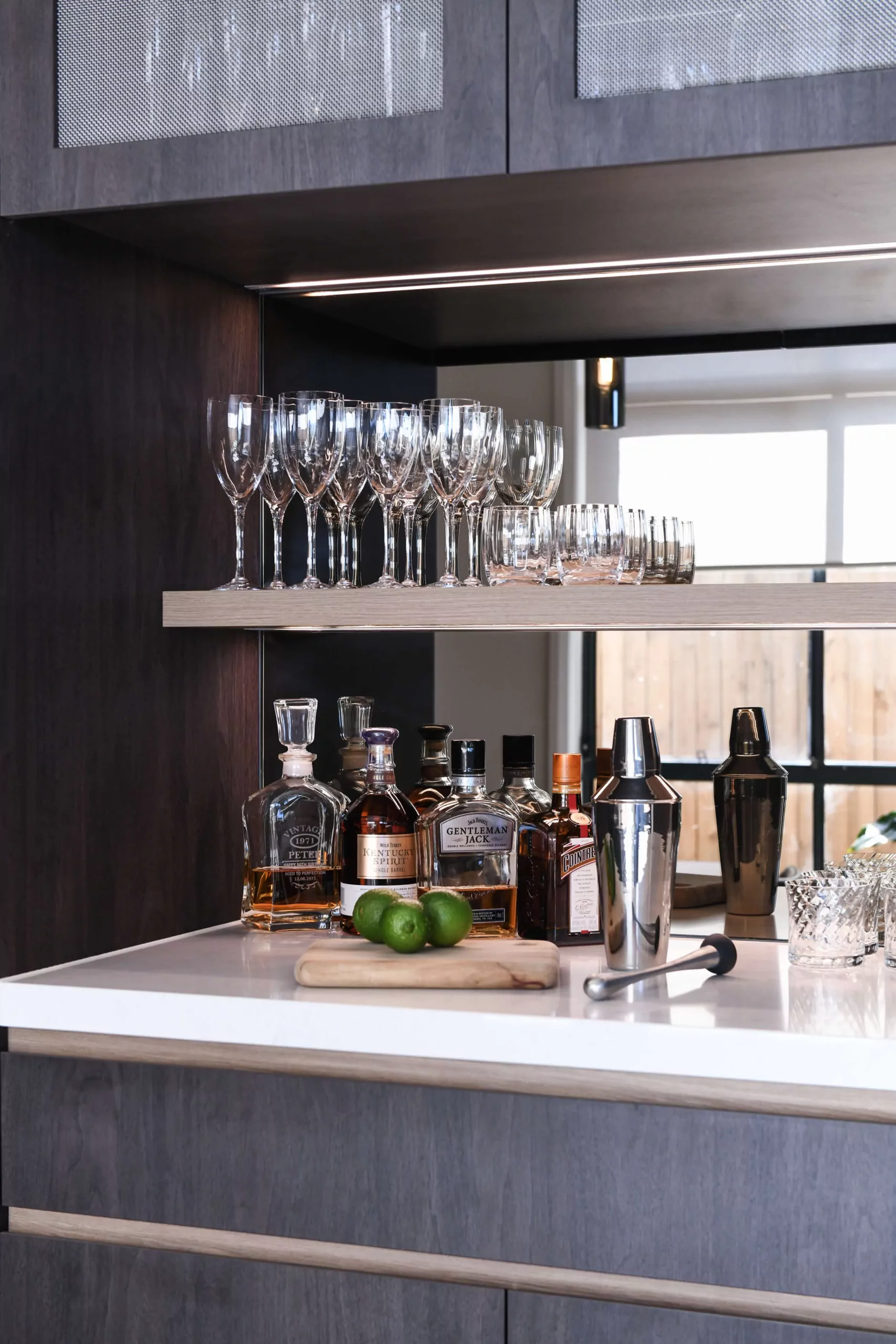 Cocktail preparation station with stone work surface and LED-lit glassware display | Custom joinery by Improva, Kingsford