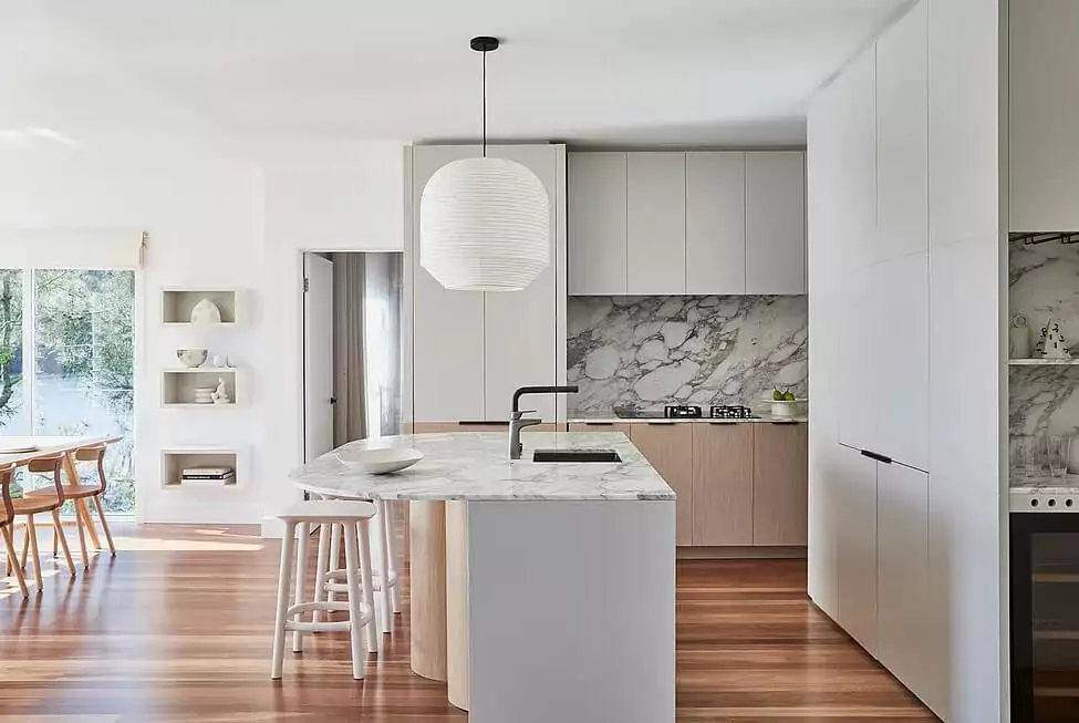 Contemporary kitchen with curved marble island and timber cabinetry | Custom joinery by Improva, Calabash Bay