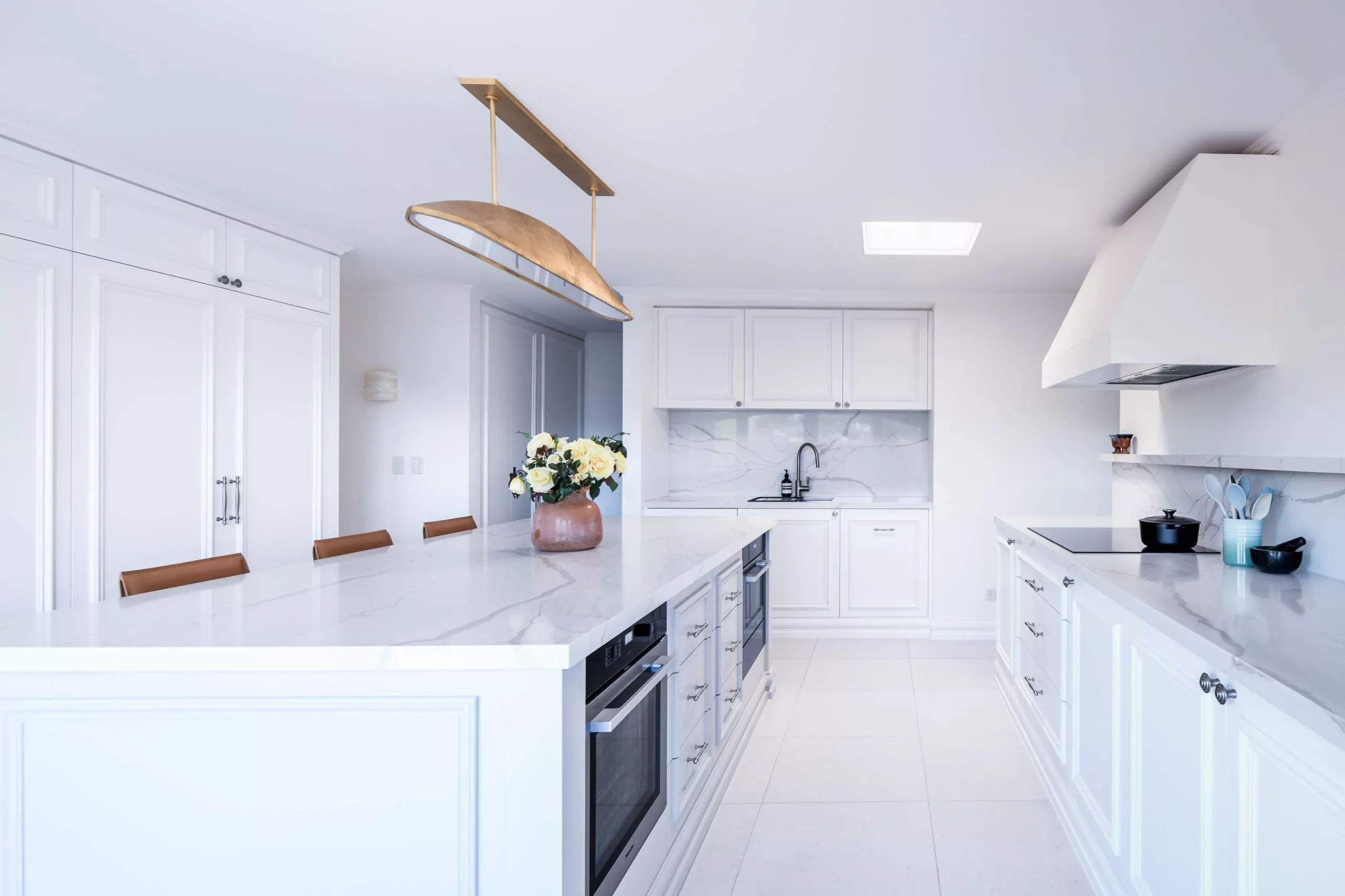 White Hamptons kitchen with marble island and integrated ovens | Custom joinery by Improva, Darling Point