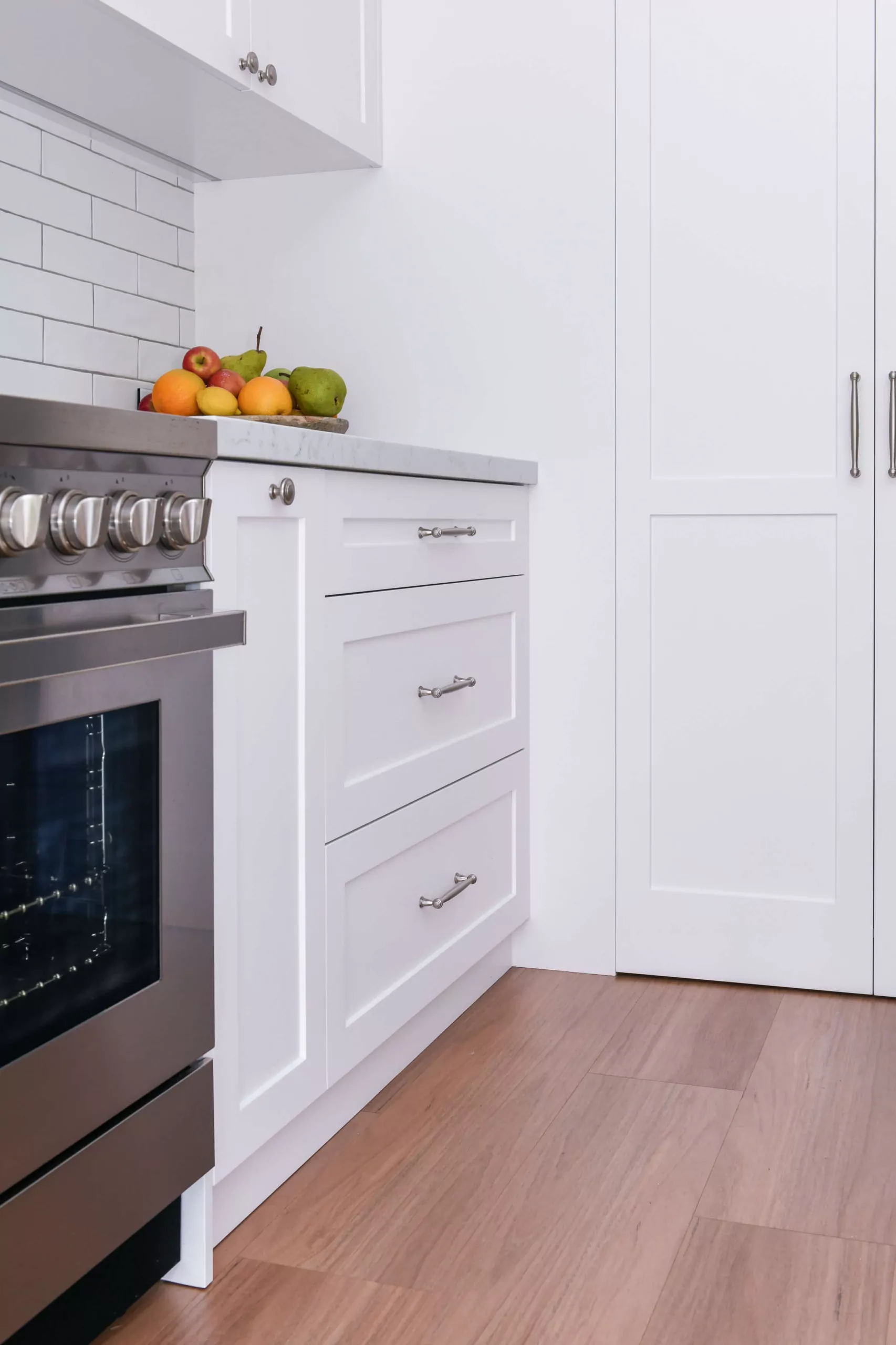 White Shaker cabinetry with chrome hardware and subway tile splashback | Custom joinery by Improva, Kingsford